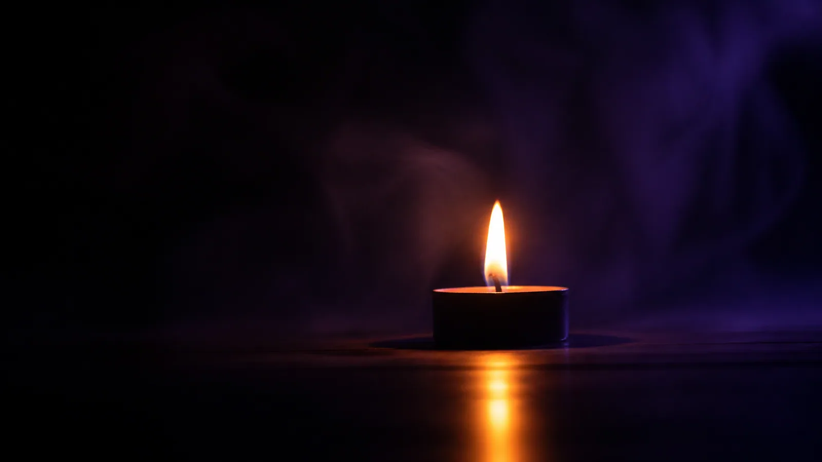 Silhouette d'une bougie unique dont la flamme se reflète sur une surface sombre, ambiance de profondeur intérieure du Niveau 3 Maître